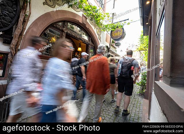 06 June 2022, Hessen, Rüdesheim am Rhein: Tourists walk through the Drosselgasse. (Wiping effect by long exposure) Rüdesheim is a popular tourist place on the...