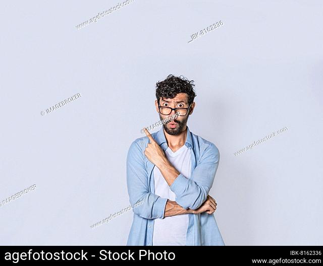 Shocked young man with new idea, shocked guy pointing finger up