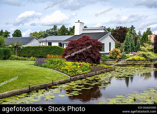 Reeuwijk, Holland, The Netherlands, July 10, 2023 - Country houses and maintained green lawns with private canals