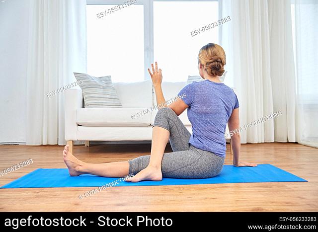 woman doing yoga twist exercise at home