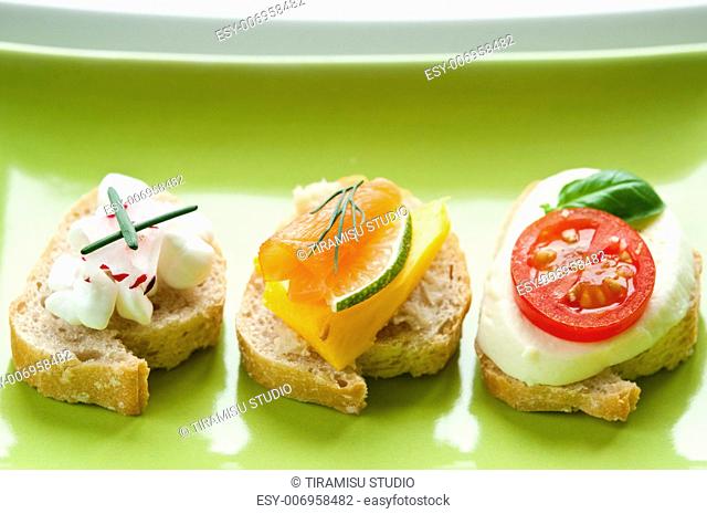 Selection of bread appetizers with smoked salmon, mozarella and cottage cheese