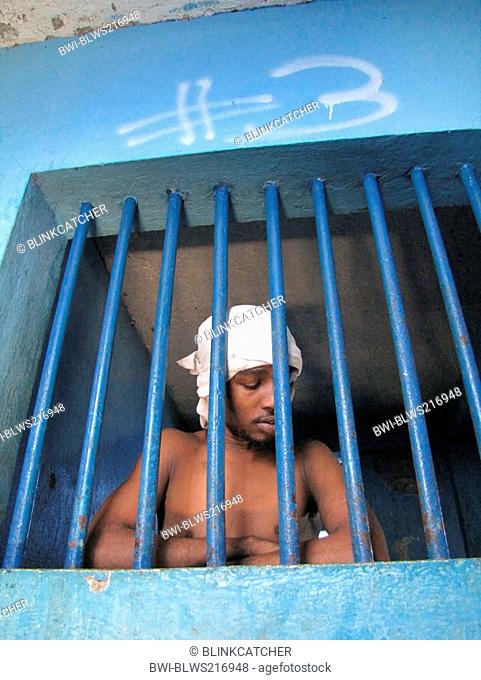 detainee behind bars of a window in run-down predetention cell garde à vue at police station, commissariat of Jérémie, Haiti, Grande Anse, Jeremie