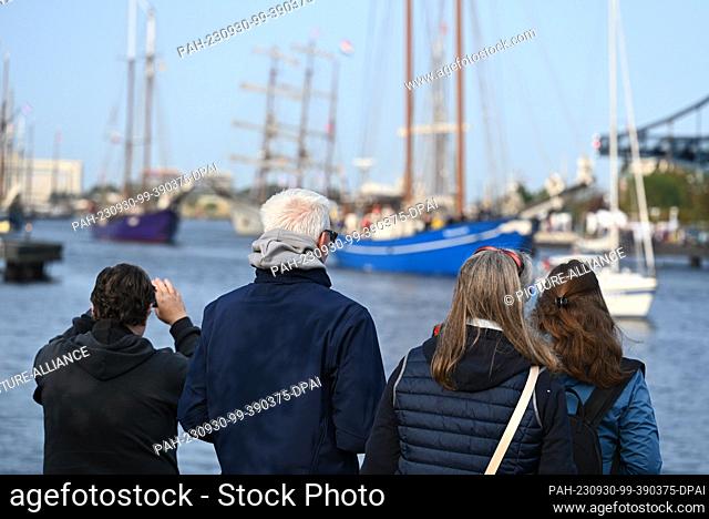 30 September 2023, Lower Saxony, Wilhelmshaven: Spectators watch the sailing ships setting sail for a regatta as part of the 21st Wilhelmshaven Sailing-CUP