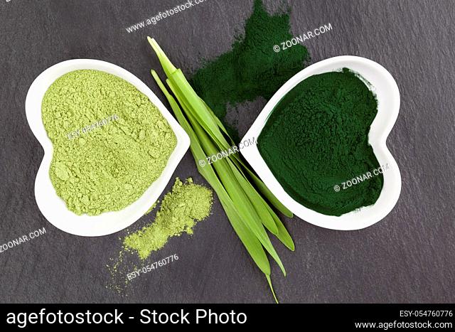 Green healthy superfood powder from above on black surface. Spirulina and chlorella