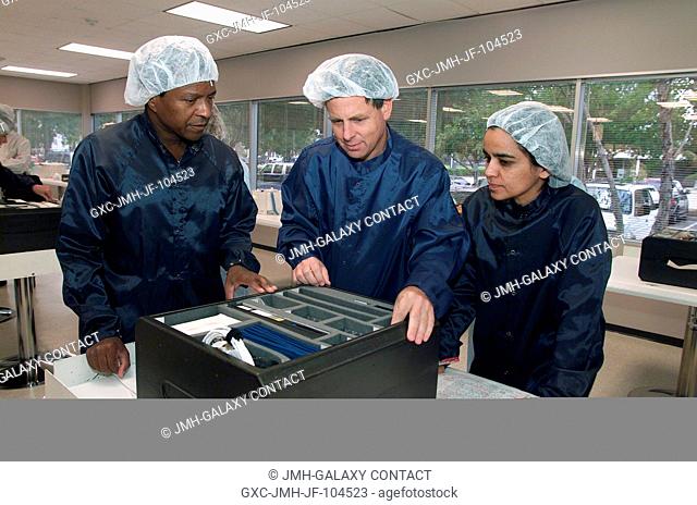 Astronaut Michael P. Anderson (left), payload specialist Ilan Ramon, and astronaut Kalpana Chawla, inspect mission hardware during a crew equipment bench review...