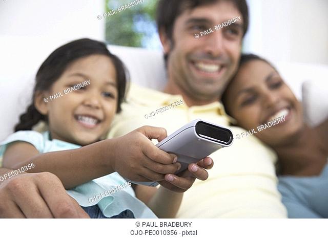Couple with daughter watching television
