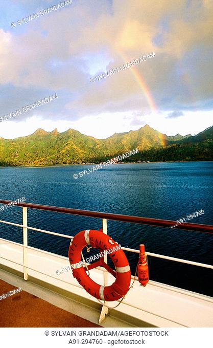 Rainbow over Huahine Island and deck of MS Paul Gauguin cruise ship. French Polynesia