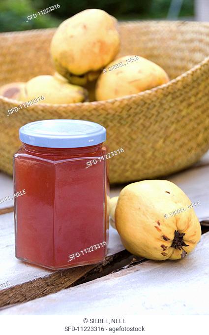 A jar of quince jelly and fresh quinces