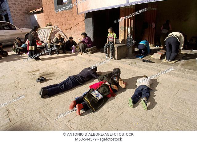 pilgrims in full prostration outside the ramoche temple. lhasa. lhasa prefecture. tibet. china. asia