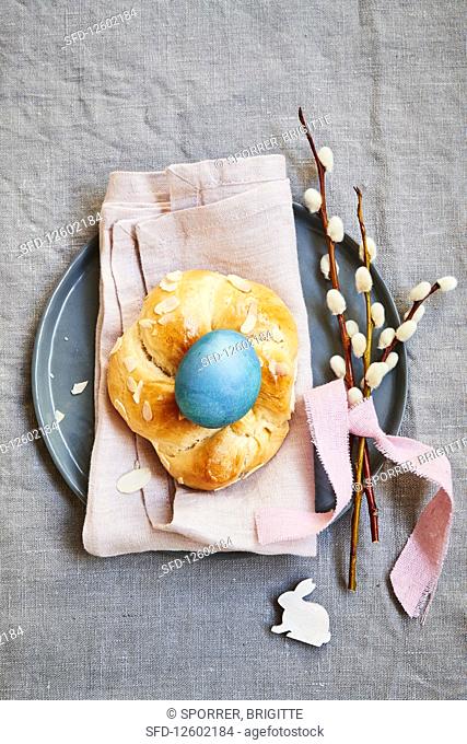 Yeast dough wreath with a blue coloured egg and pussy willow