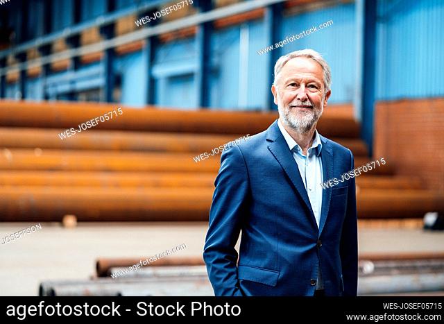 Senior businessman standing in factory