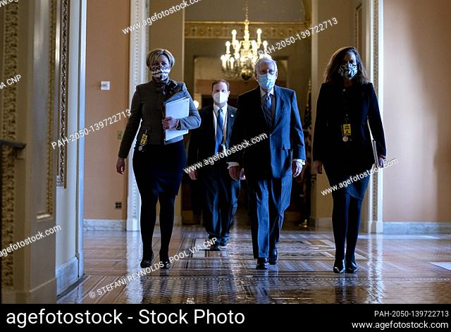 Senate Minority Leader Mitch McConnell, a Republican from Kentucky, center, wears a protective mask while walking to the Senate Chamber at the U.S