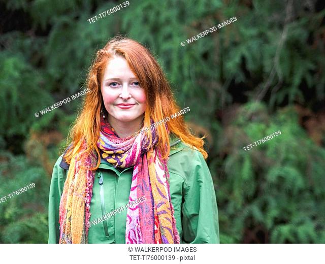 Portrait of smiling redhead in scarf and green jacket