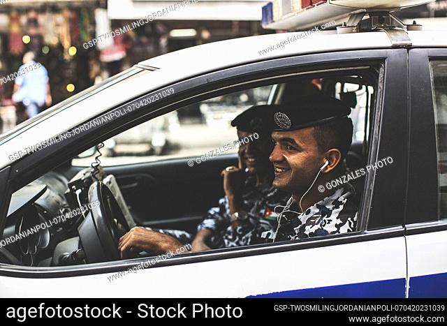Two smiling police officers in a car from the Jordanian Police in Amman, Jordan