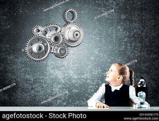 Little girl scientist with microscope on chalkboard background with gears mechanism. Research and discovery concept. Elementary science class in modern school