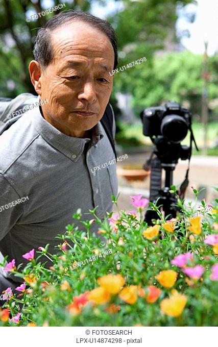 Senior man looking at flowers