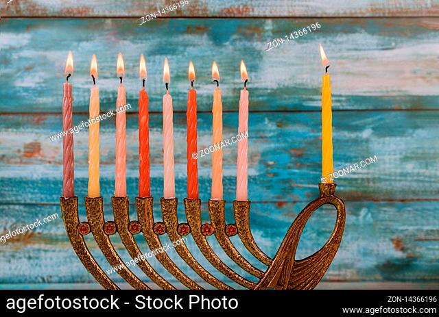 Menorah with colorful burning candles for Hanukkah on light, close up