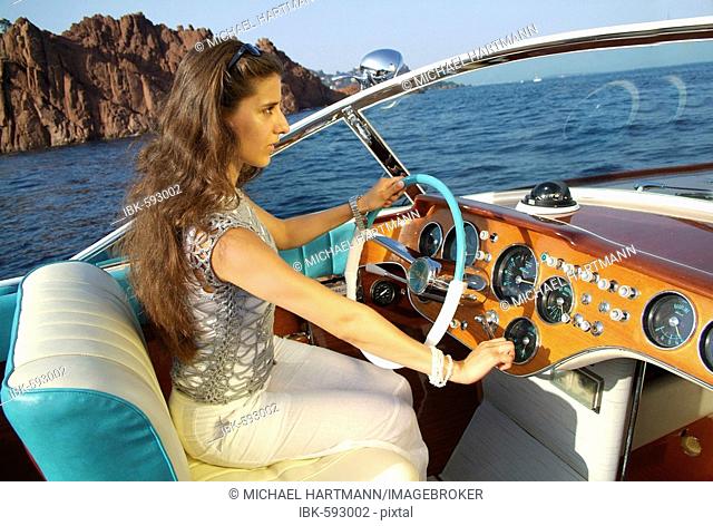 Young woman at the wheel of a Riva Motorboat, Théoule-sur-Mer, France, Europe
