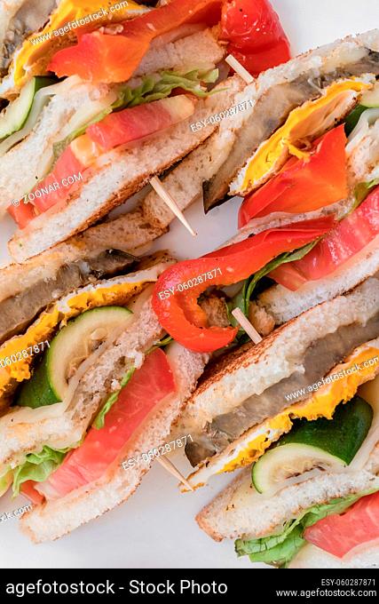 Vegetarian sandwiches. Healthy toasts with omelette, peppers, courgettes and tomatoes for breakfast or lunch. Plant-based diet. Whole food concept