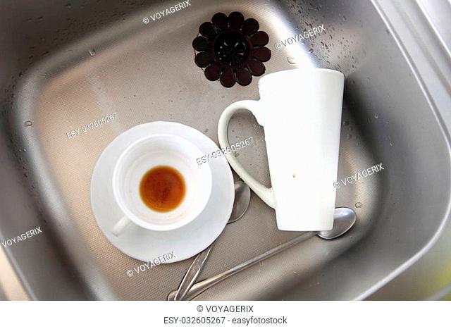 Washing up. White coffee cups in the kitchen sink