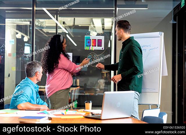 Multiracial colleagues explaining business plan to manager over diagram in meeting