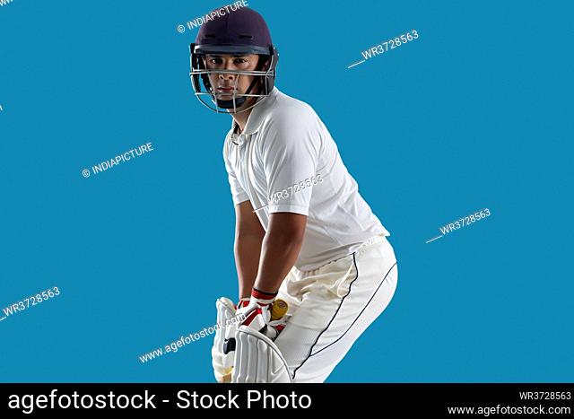 batsman ready to face the ball, isolated over Blue background