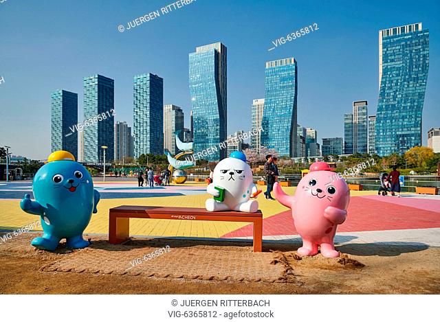 SOUTH KOREA, INCHEON CITY, 19.04.2019, oversized colorful toy figures in Central Park in Songdo International Business District with skyscraper in the back