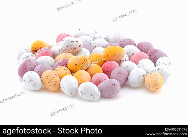 A selection of Yellow pink purple and white Easter candy eggs isolated on a white background
