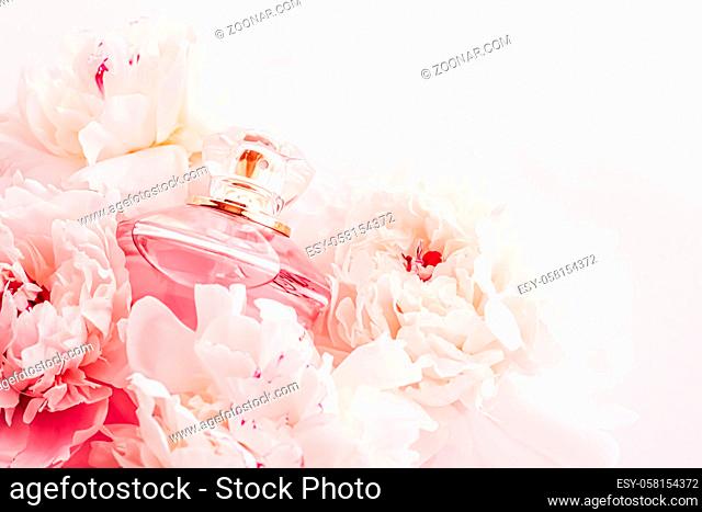 Luxe fragrance bottle as girly perfume product on background of peony flowers, parfum ad and beauty branding design