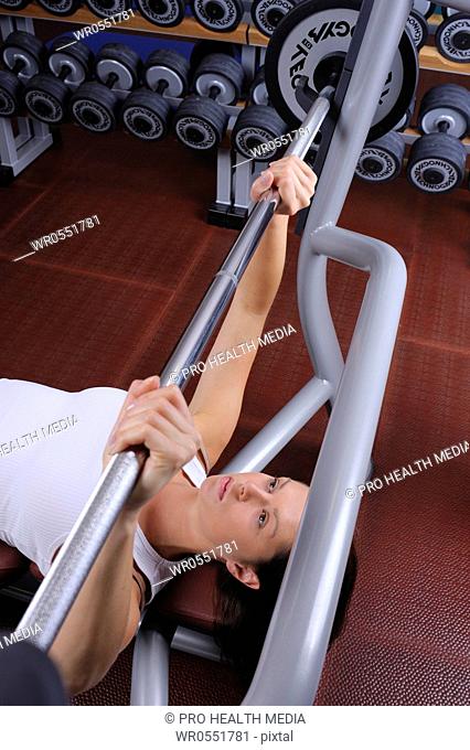 young woman in a fitness center weight lifting