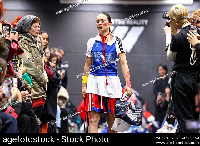 16 January 2023, Berlin: An activist walks the catwalk at a performance disguised as an Adidas show during Berlin Fashion Week