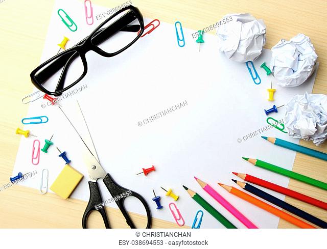 School supplies with white paper on the wood desk background