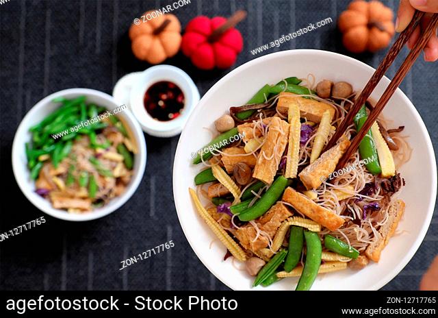 Dry rice vermicelli fried with vegetables from top view, a Vietnamese vegetarian dish for vegans, a dish can make quick for breakfast at home from noodle