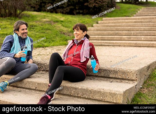 Mature couple with bottles sitting on steps