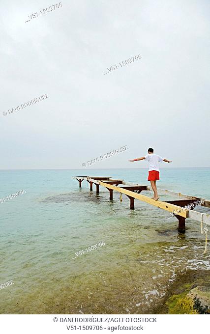 Man doing balance in a pier in Formentera, Balearic Islands