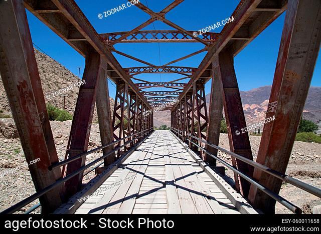 Photograph of a steel bridge construction over a dry river bed in Tilcara, Argentina