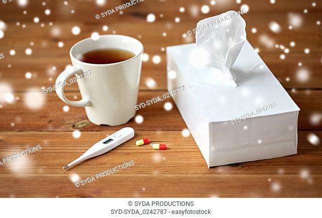 cup of tea, paper wipes and thermometer with pills