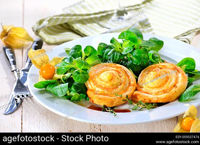 Herzhafte Blätterteig-Lachsschnecken mit Frischkäse und Kräutern auf Feldsalat - Baked hearty puff pastry snacks with smoked salmon