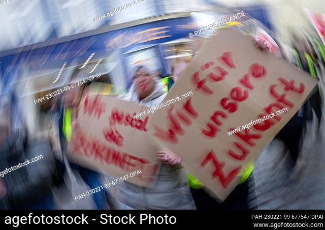 21 February 2023, Mecklenburg-Western Pomerania, Schwerin: Union members carry cardboard signs reading ""We for our future"" during a procession through the...