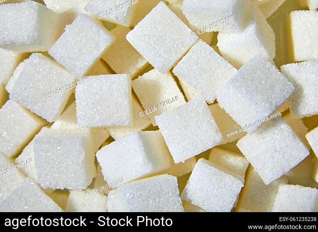 Flat lay macro white sugar cubes close up texture background, diet health risks related to diabetes and calorie intake