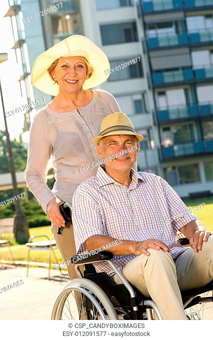 Wealthy senior man in wheelchair with wife