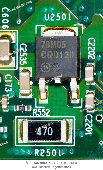 close up photograph of electronic components on a computer mother board showing a voltage regulator chip