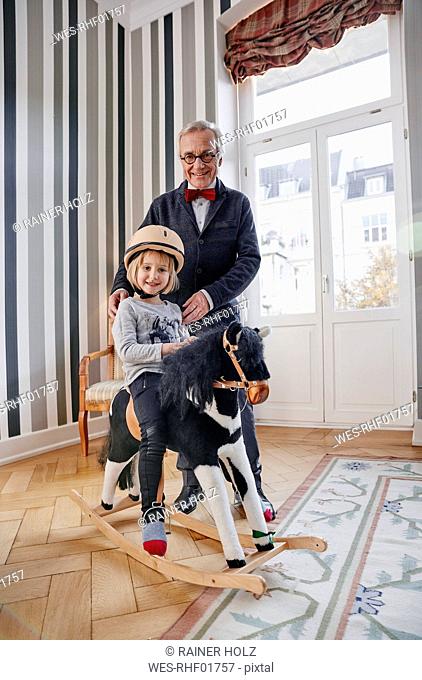 Grandfather and granddaughter on rocking horse