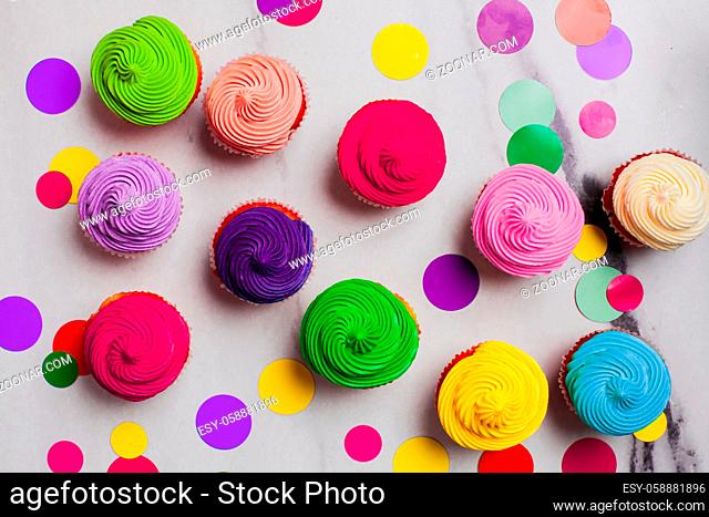 Colourfull cupcakes flat lay on the marble background - vivid sweet pattern, concept of positive blowe up