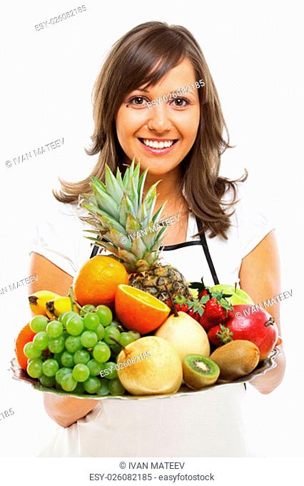 Young woman holding a tray with fresh fruits - apples, pears, grapes, pineapple, oranges, kiwi, strawberries and others