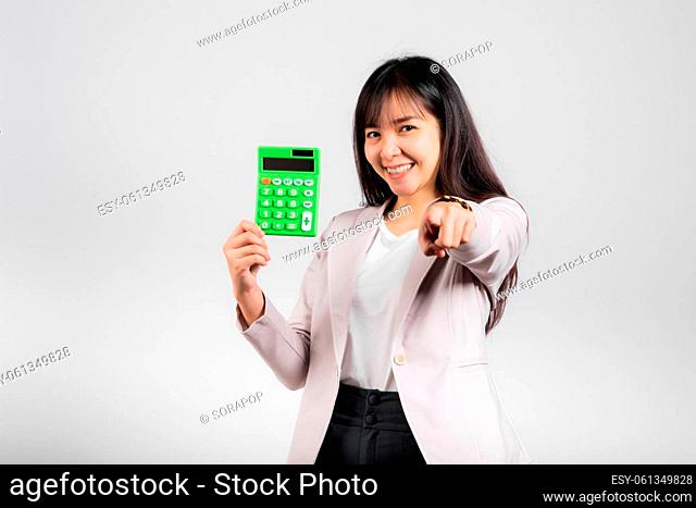 Tax day concept. Woman confident smiling holding calculator and finger point to camera, Portrait excited happy Asian female studio shot isolated on white...