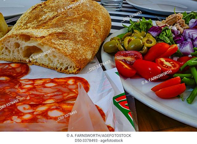 Syracuse, Sicily, Italy A dinner plate consisting of olives, bread, salami, tomatoes, onions, peppers, beans