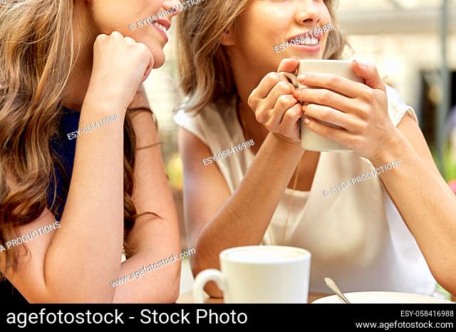 close up of young women with coffee cups at cafe