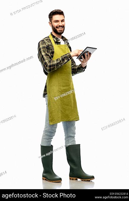 happy male gardener or farmer with tablet pc