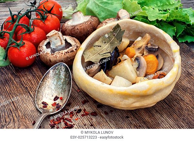 mushrooms baked with potatoes in bread pot amid onion and tomato